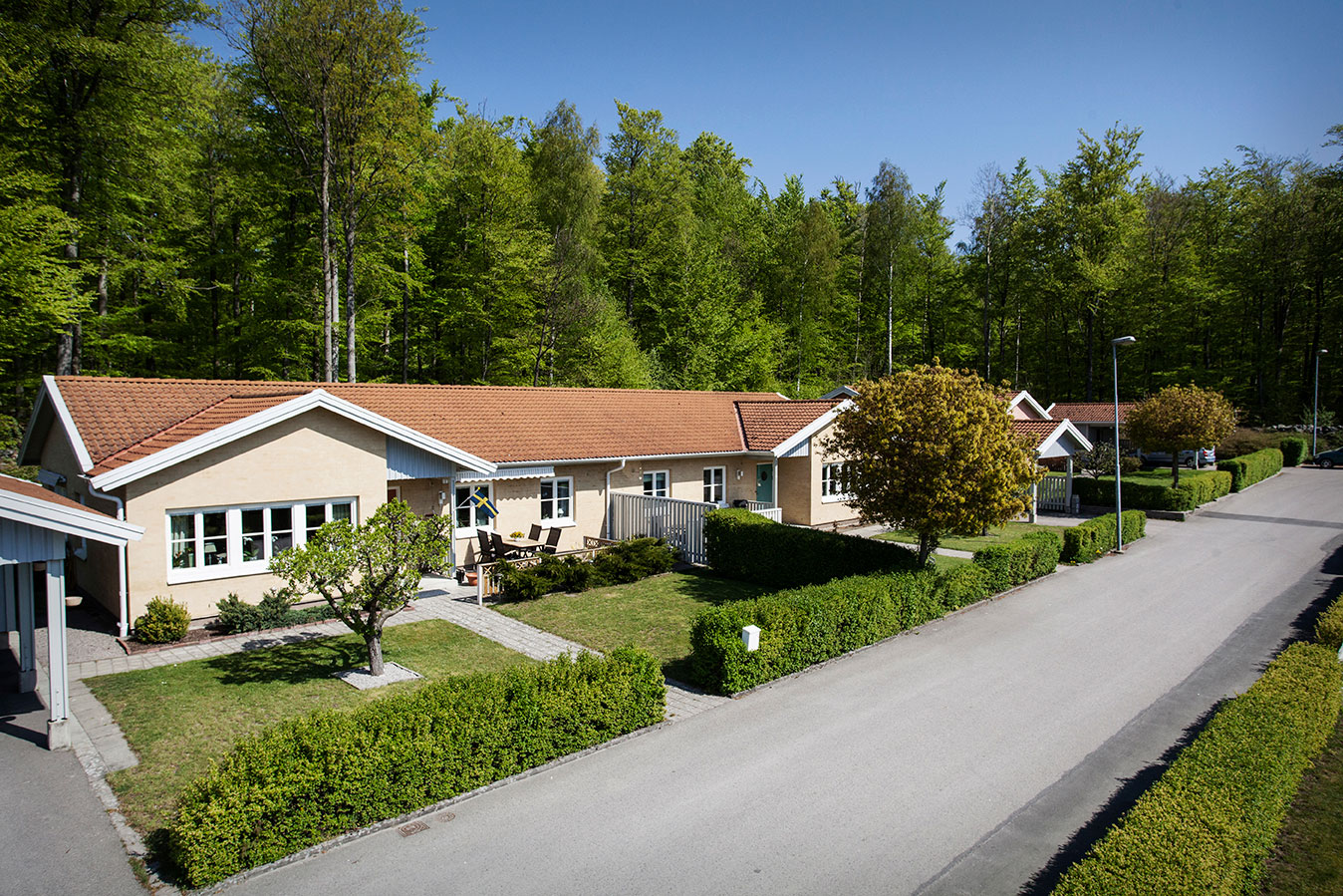Framsidan av Sölvesborgshems lägenheter på Daggkåpevägen, Murgrönevägen och Puktörnevägen med härligt grön skog bakom